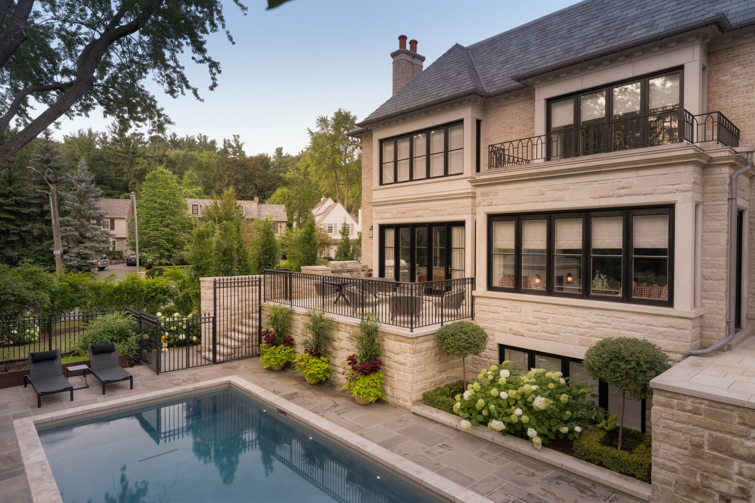 Elegant house with spacious patio, pool, and garden. Surrounded by lush greenery and other homes, creating a serene, upscale neighborhood setting.
