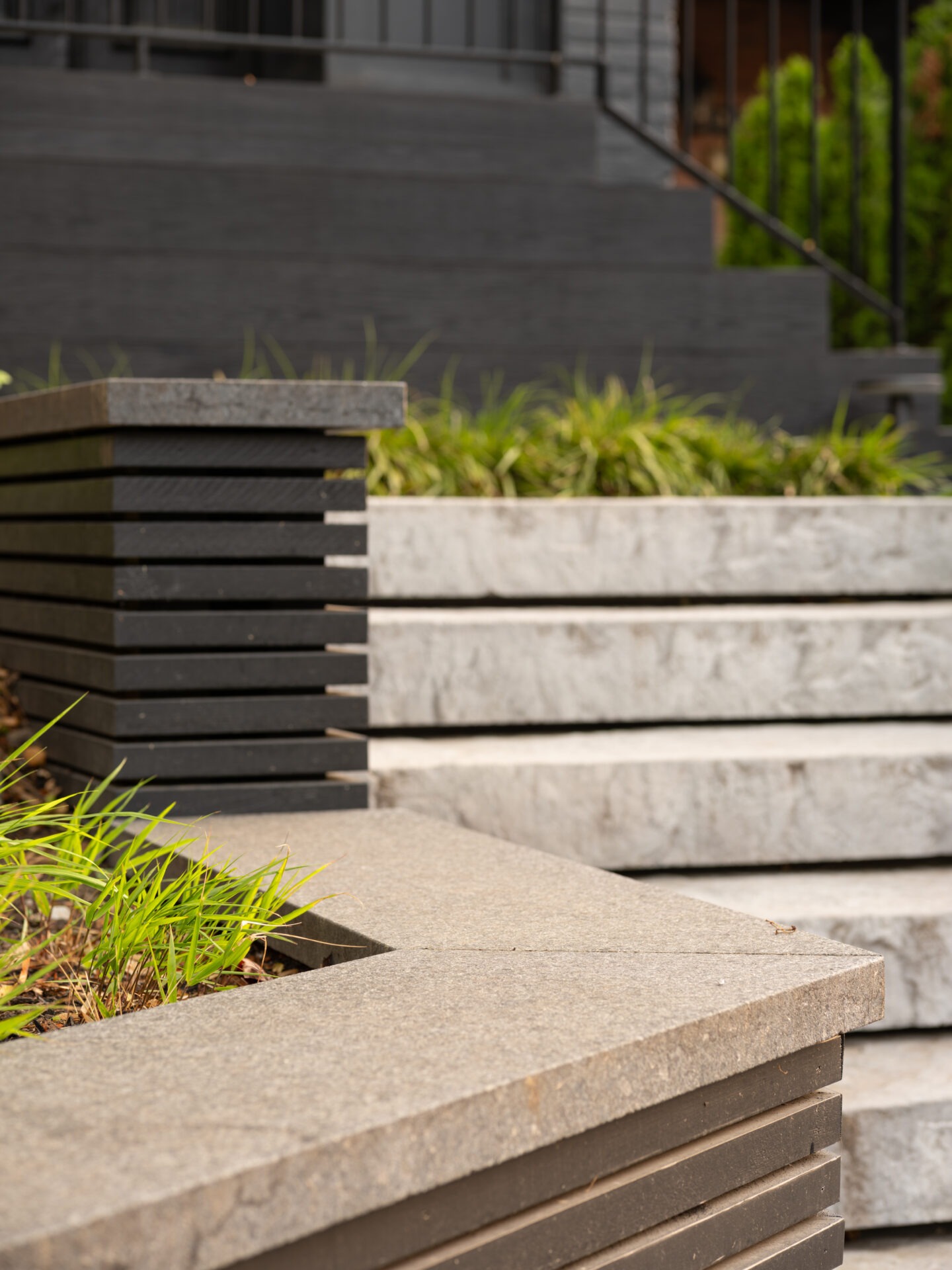 Modern concrete steps and planter with green plants, leading to a building entrance. No people or recognizable landmarks are visible.