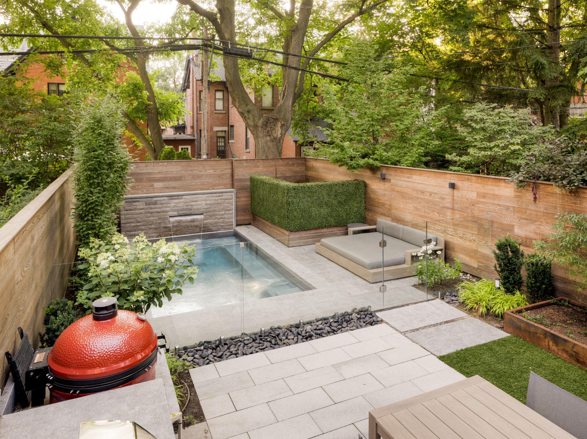 Backyard plunge pool with stone patio and privacy fencing