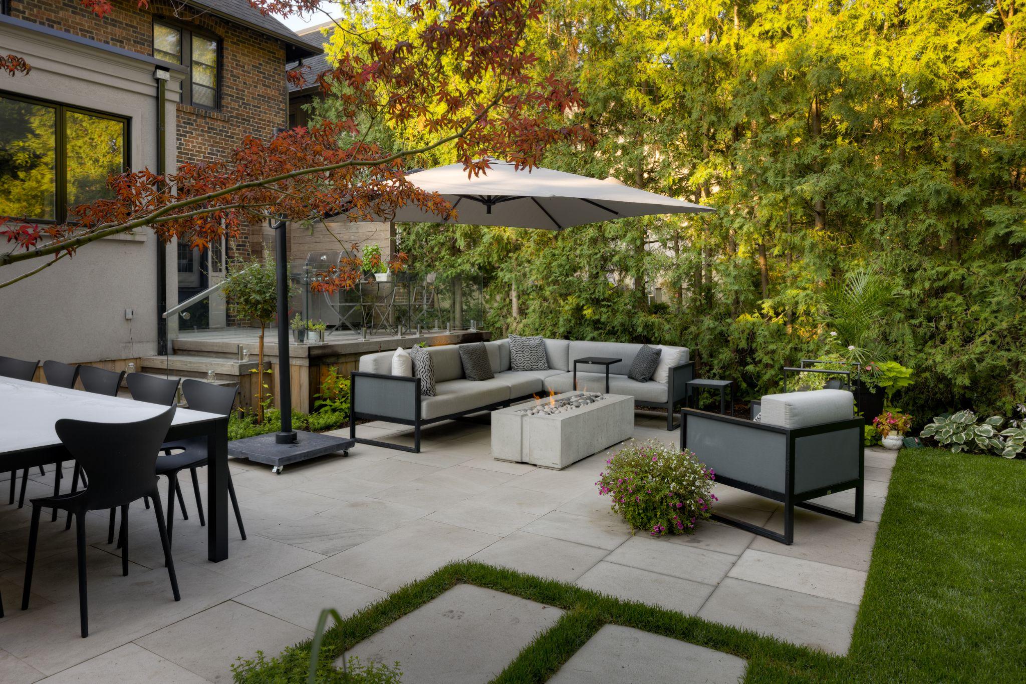 Modern backyard patio with large concrete pavers and outdoor seating